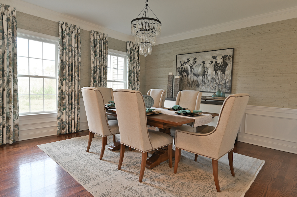 For a dining room that reflects her clients’ personalities, designer Danielle Sacco infused natural elements such as a spa-blue grass cloth above dove-white wainscoting. The décor combines with the glamour of a Minka Lighting chandelier over a farm-style table for a room rich in character.