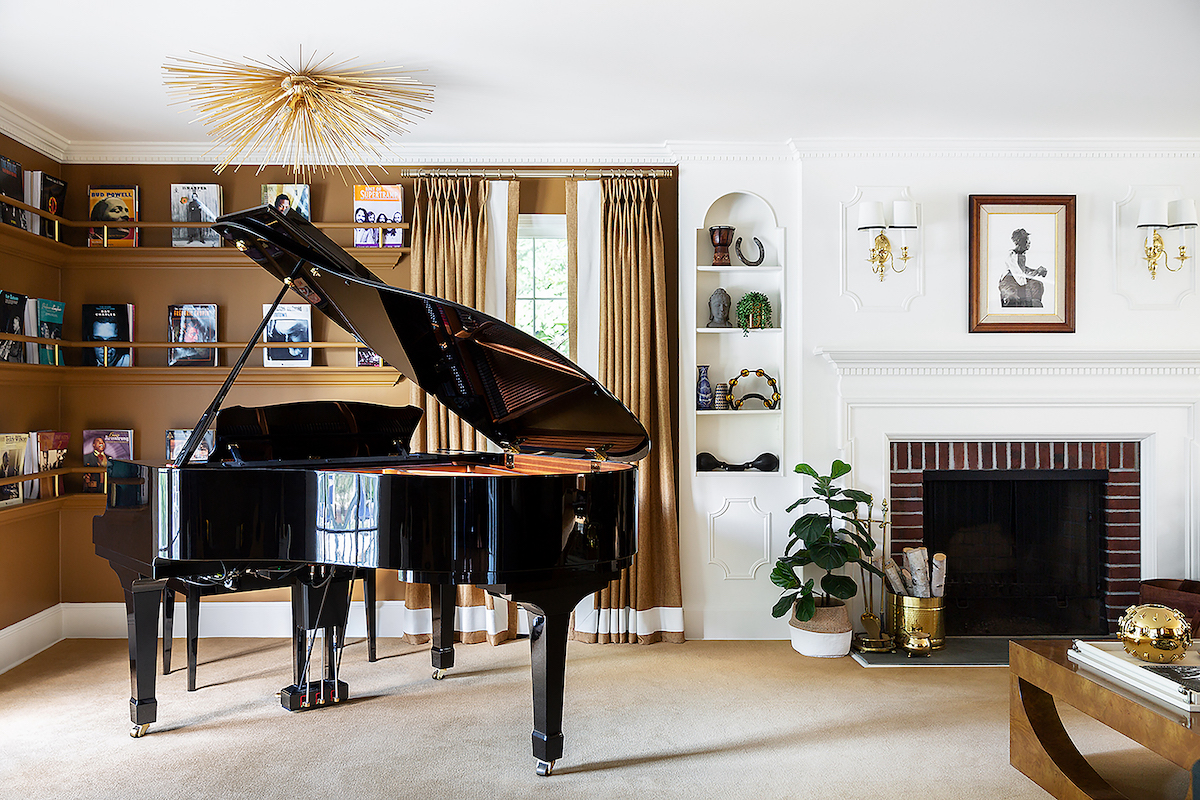 In the music room of an Upper Saddle River home, the Yamaha Disklavier piano resonates with classic elegance while the Kelly Wearstler brass chandelier, Stark carpet and eclectic art add harmonious notes.