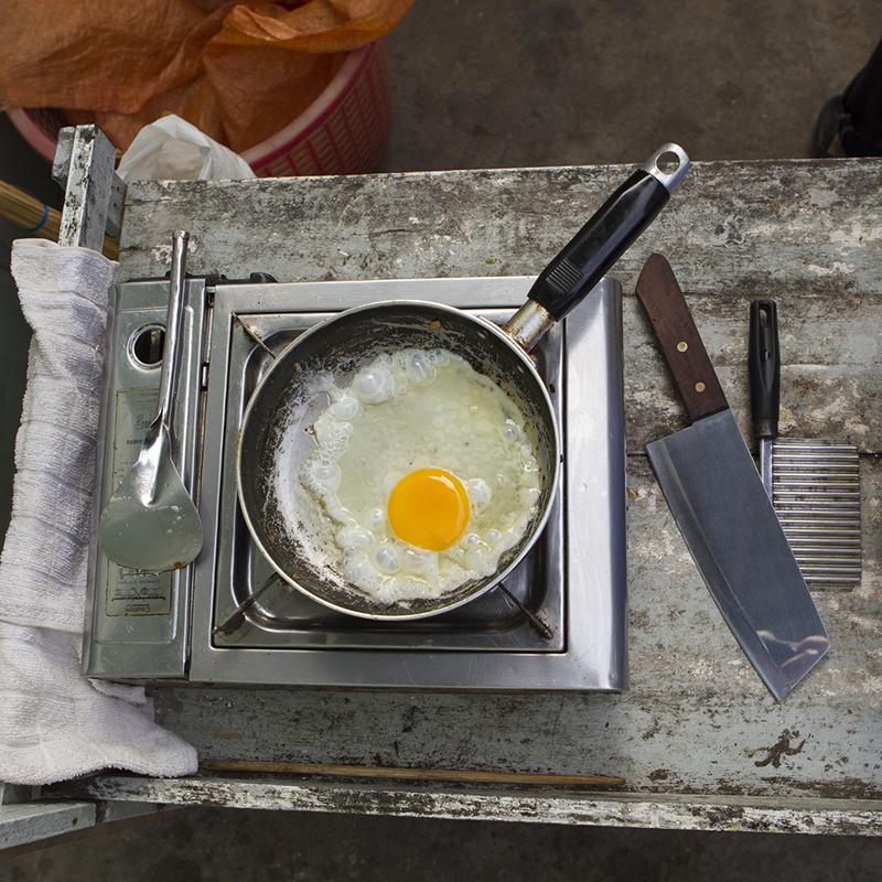 Egg frying in pan on hot plate, overhead view