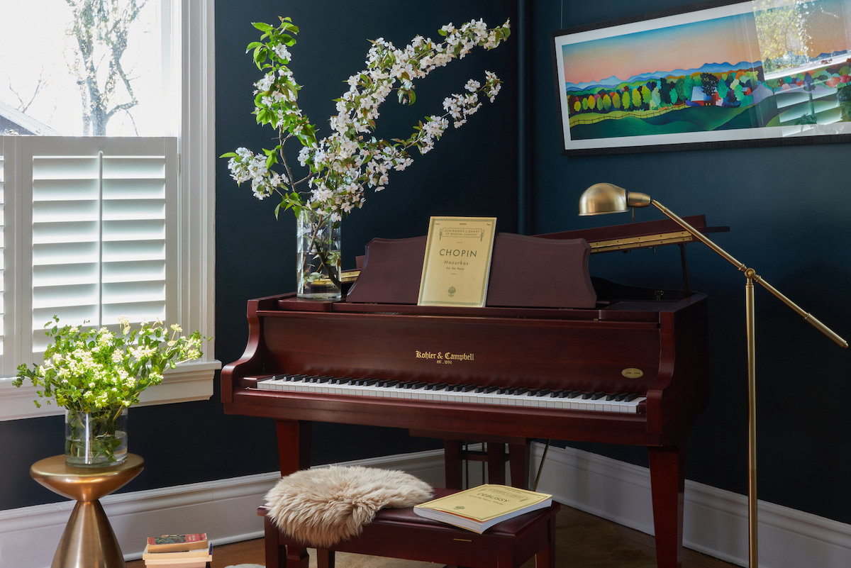 Because the homeowners’ vintage baby grand piano was a natural focal point in the living room, the designer added more subtle contemporary touches, like the Corso cocktail table from West Elm and the antique finish pharmacy floor lamp from Dawson.