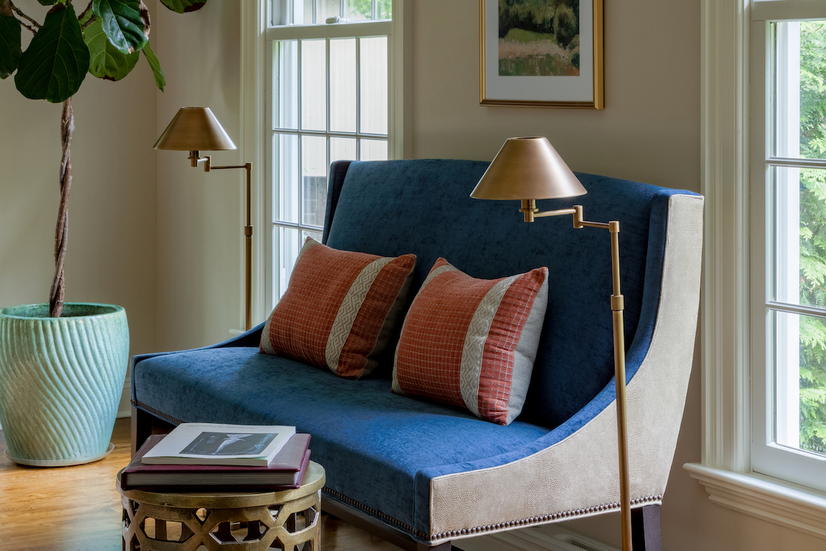 A seating area perfect for enjoying a good book was created with a custom-made blue settee sporting suede leather. The fiddle-leaf fig tree in the corner adds a natural element to the room. 
