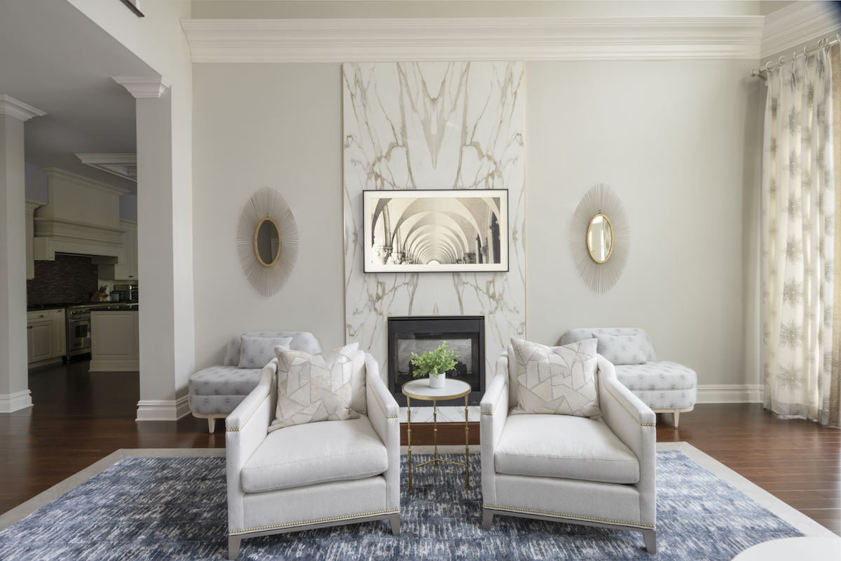 For the look of Calacatta marble on the fireplace, DiGiacomo introduced a porcelain slab trimmed in gold, keeping costs down. The artwork is no ordinary painting, but a Samsung Frame TV.
