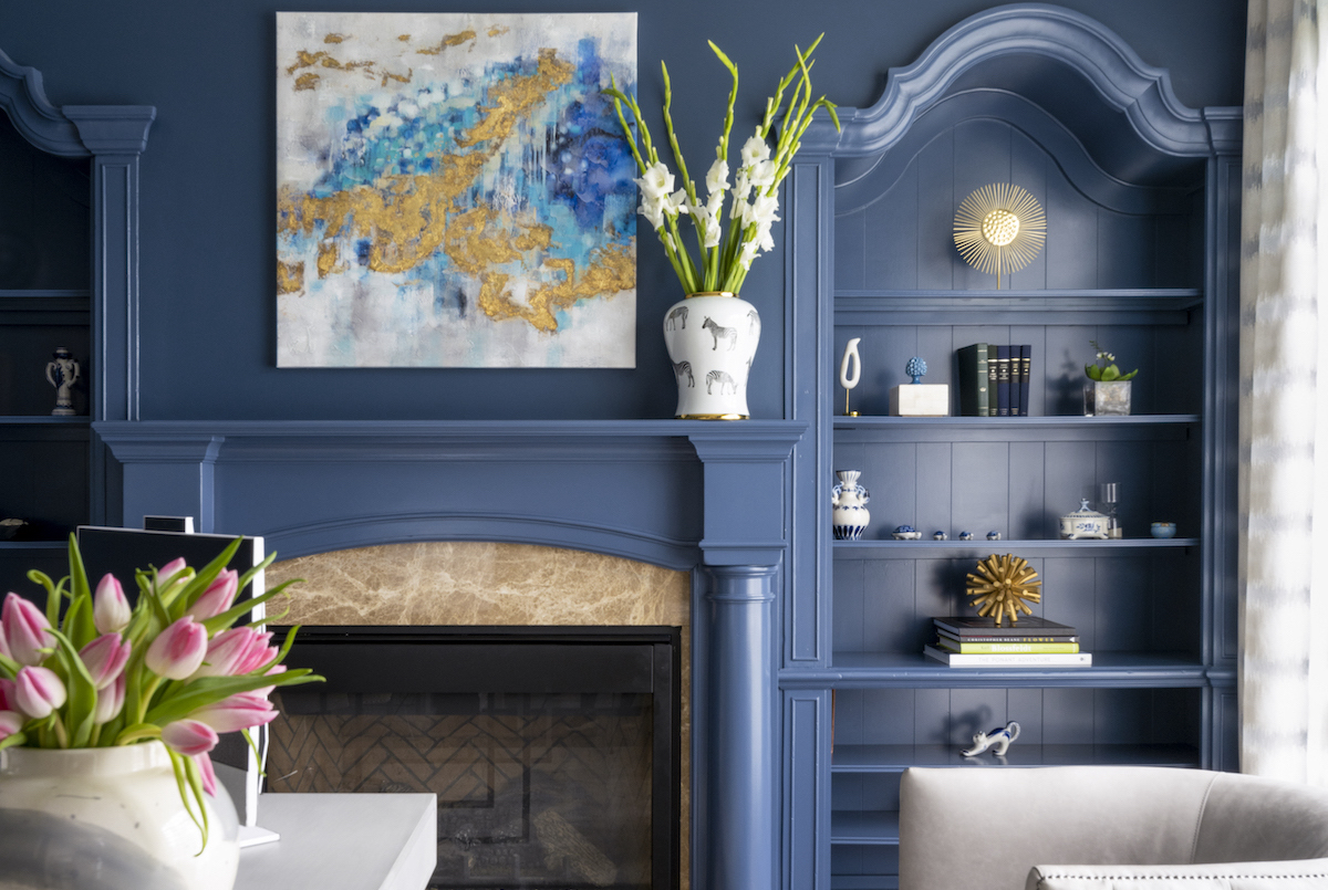 An abstract above the fireplace is like a bouquet of color, while the built-ins let the homeowner, who is a doctor, highlight family and career
