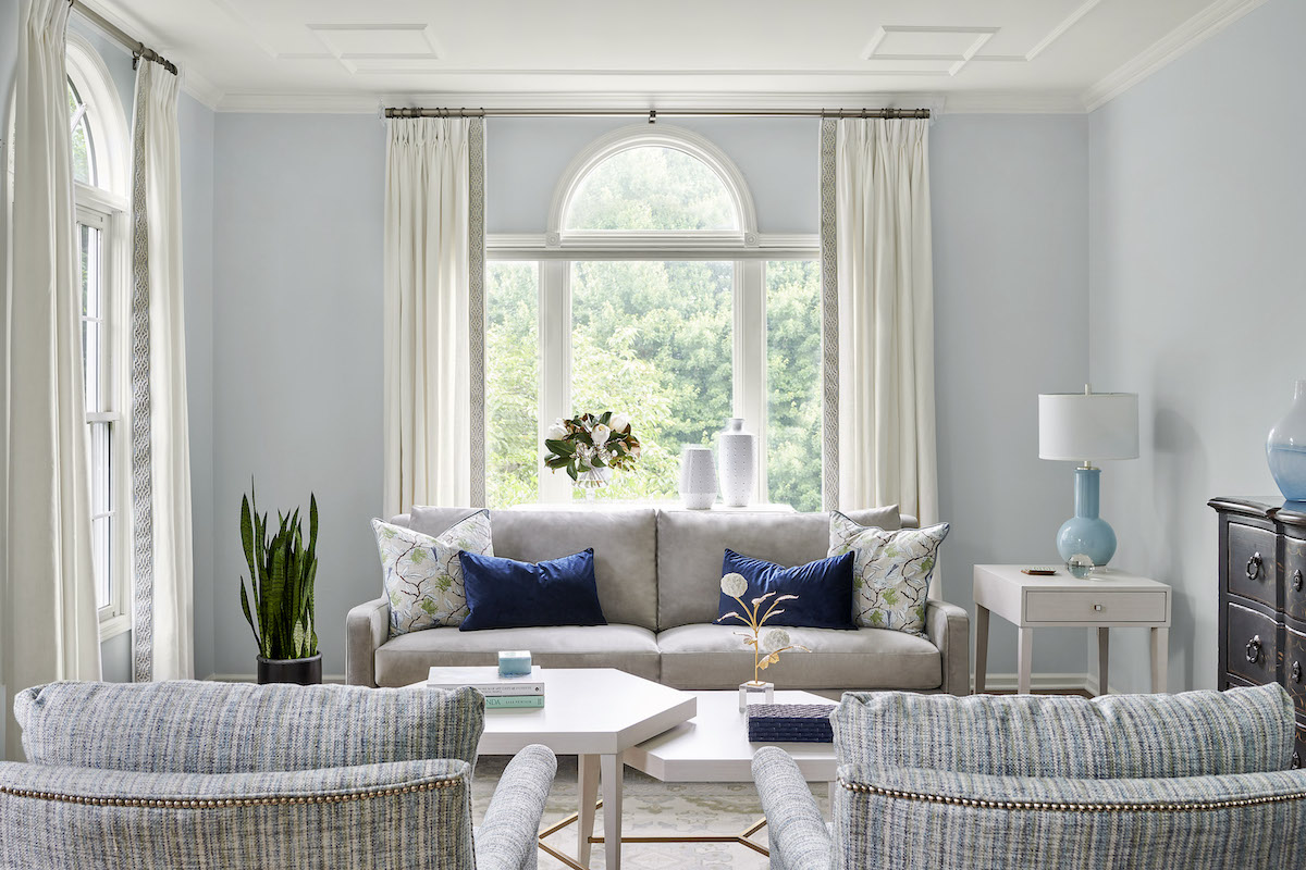 Opposite: Nicknamed the “pretty room” by the homeowners, the living room features a pleasing palette of blues and greys. The Greek key ceiling molding is one of the designer’s favorite features. “It elevates the space with an elegant touch,” she says