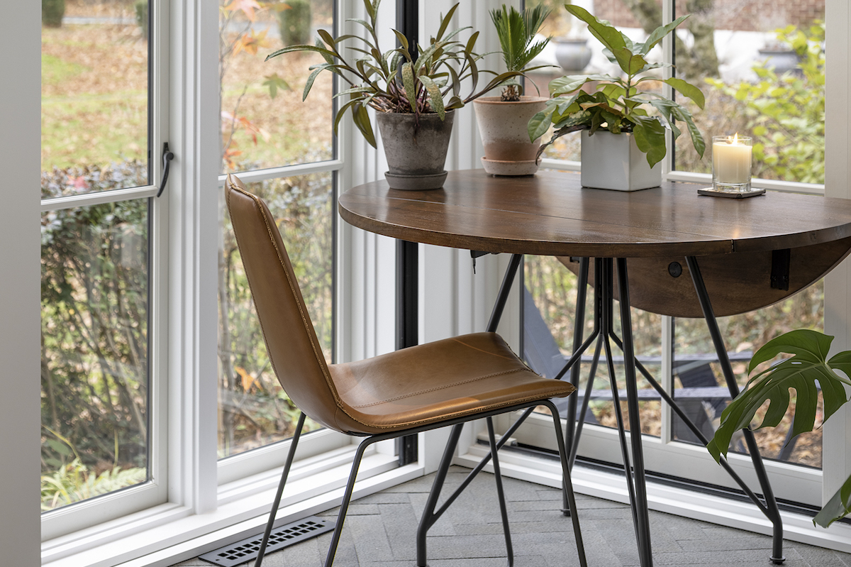 A gathering spot for family and friends, the sunroom features a small, sleekly modern table and chairs from Pottery Barn for informal meals and other casual get-togethers.
