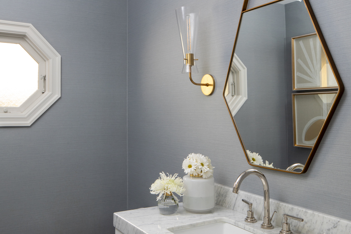 Lovell mirror, Anya wall sconces and Glazzio floor tile contribute to the powder room’s artful simplicity.