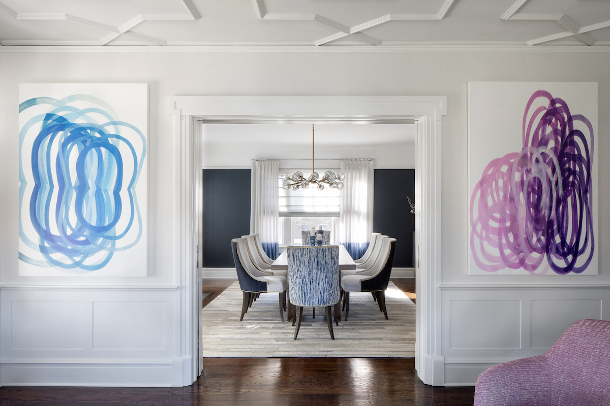 Two abstract paintings continue the room’s striking color scheme and lead visually into the formal dining room.