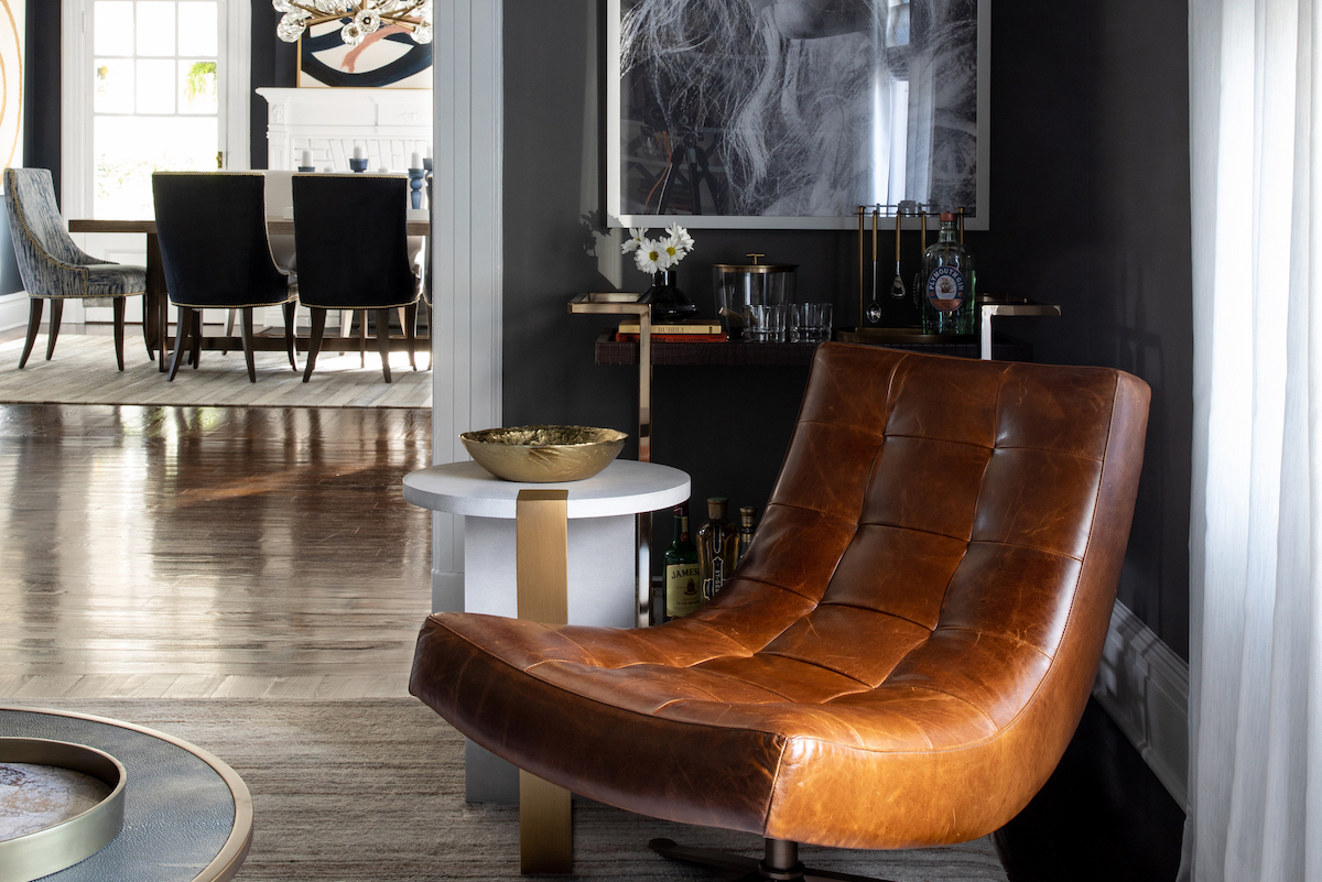 In the lounge, one of four Barcelona-style chairs from Lee Industries—this one in tan leather—makes a strong midcentury modern statement. The custom-colored art print from Art Addiction adds to the drama.