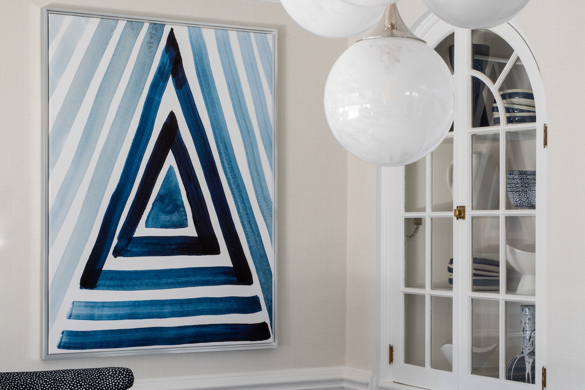 The modern triangular wall art by Rachel Brown off- sets the quaint arched niches. 