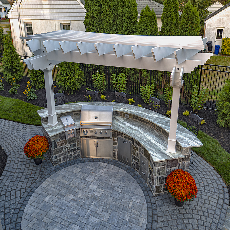 The barbecue island is designer Rich Andreu’s favorite part of the design, complete with a curved countertop and uplit pergola.