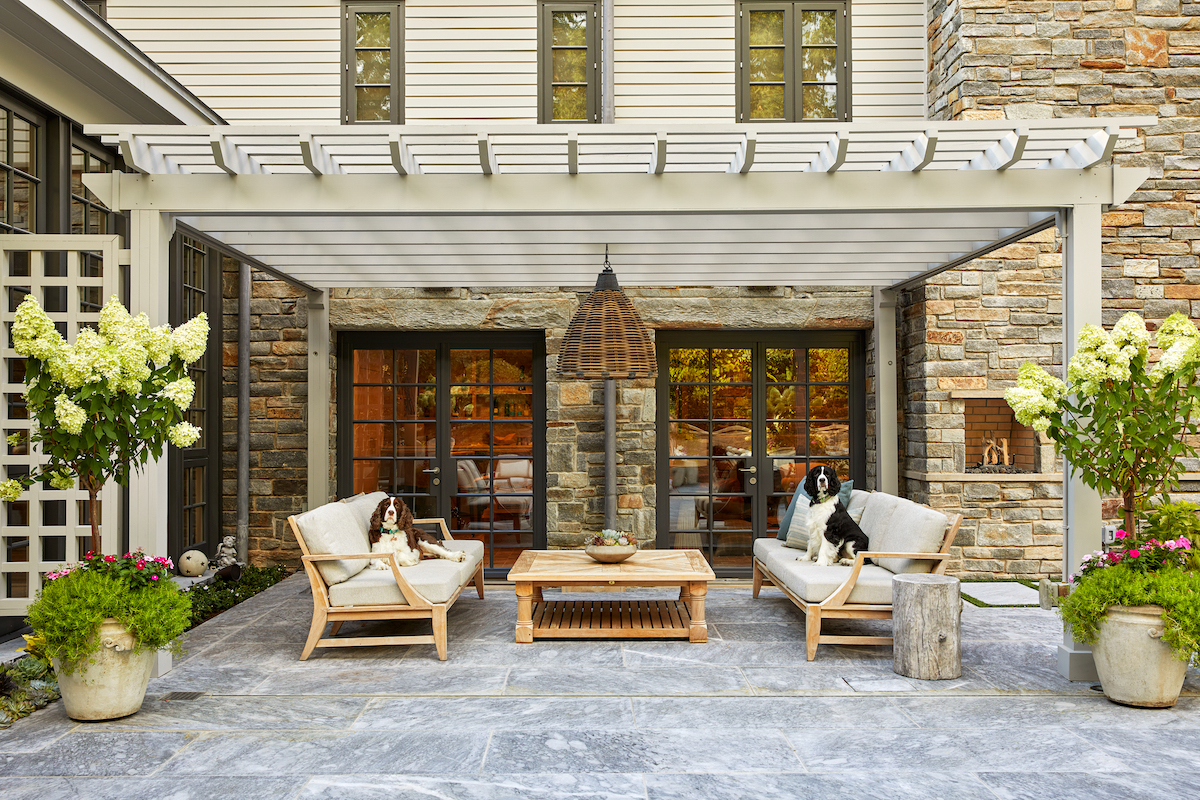 The homeowners’ English springer spaniels give the pergola’s new furniture the seal of approval, while performance fabric keeps it like new.