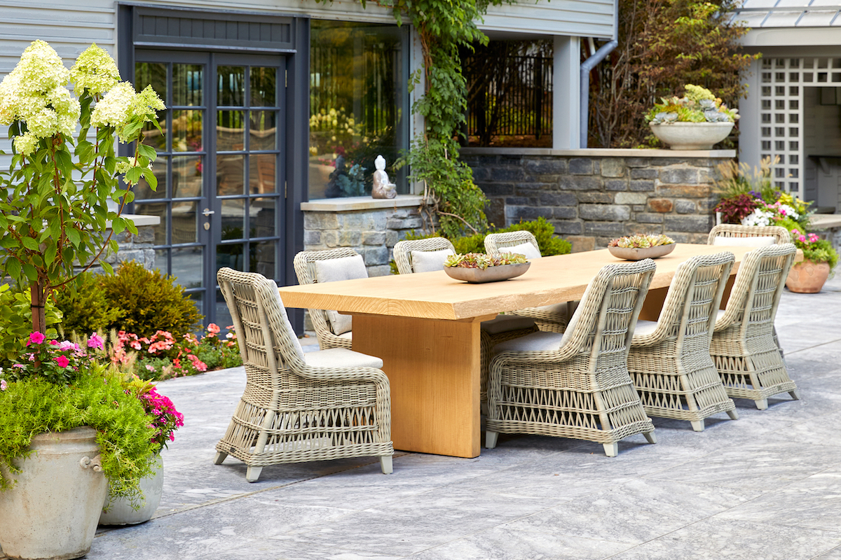 A concrete artist crafted this teak-replica, live-edge table to fit one and all while standing up to Jersey weather.