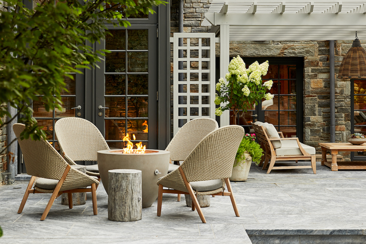 Guests can get toasty in the glow of a custom concrete firepit on high-back loungers by Janus et Cie.